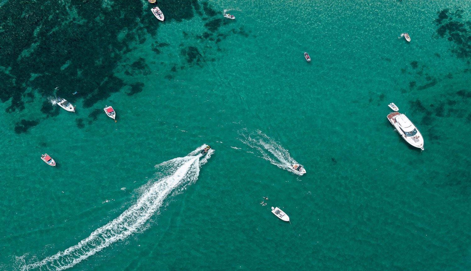An aerial view of a deep sea-green ocean with some boats floating on different directions and with different speed, Crossover, Portsea - Mornington Peninsula VIC
