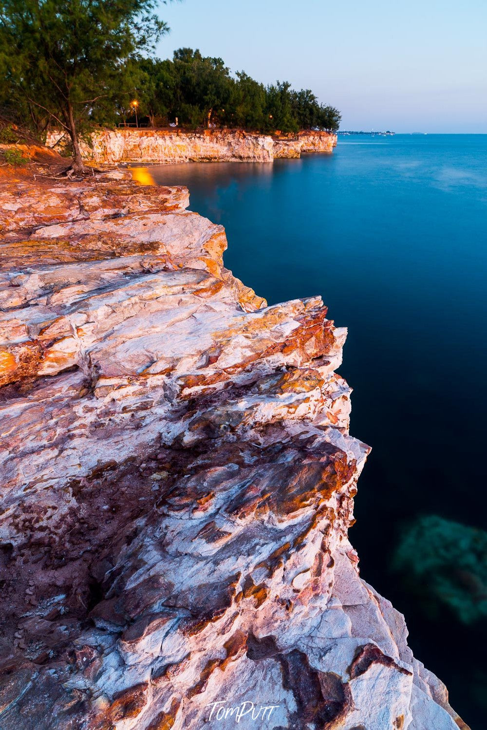 A long mountain wall with cliff texture in the ocean with some plants in the top left corner, Arnhem Land 16 - Northern Territory 