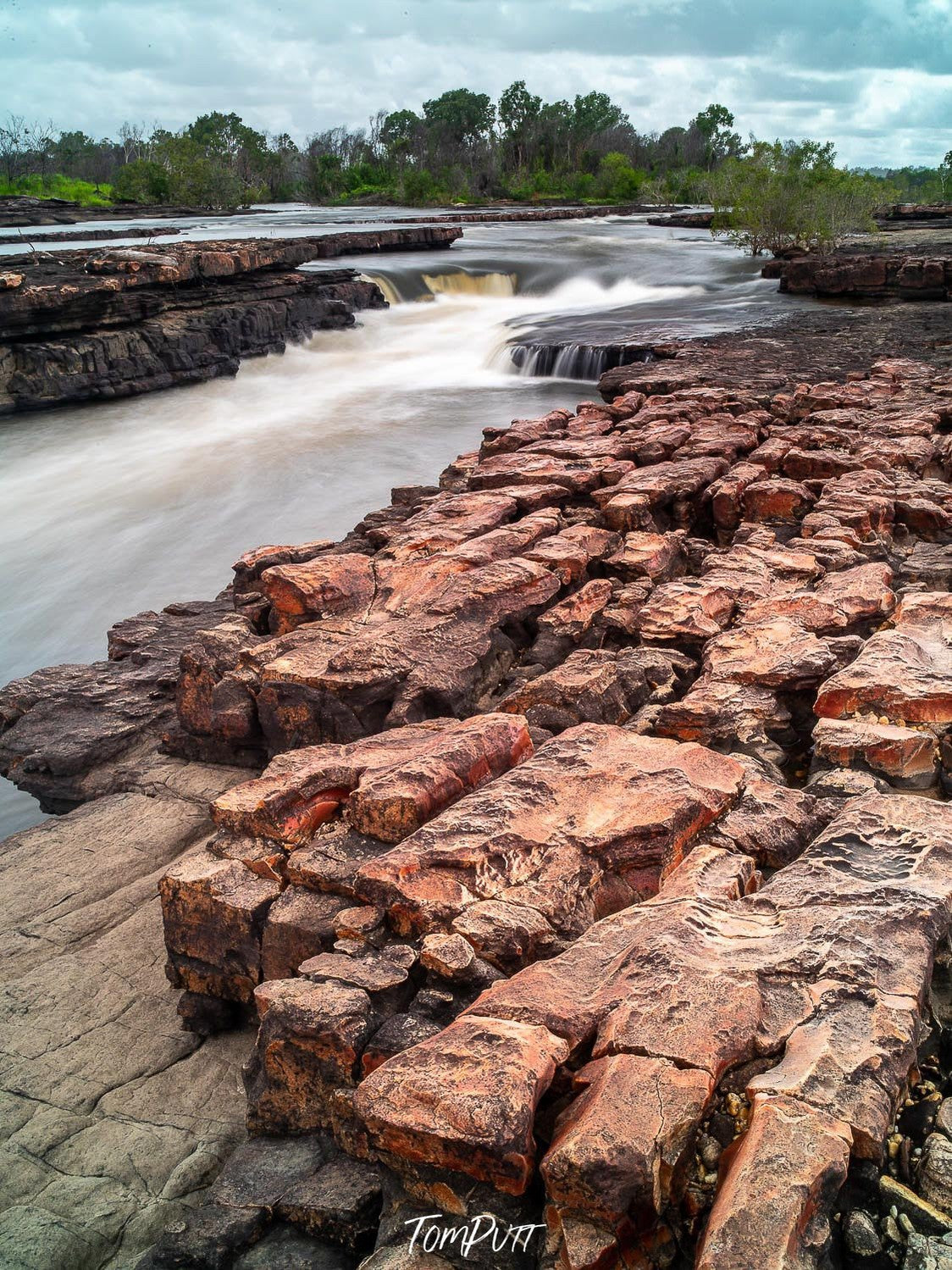 A beautiful flowing water canal surrounding with mountainy rocks of similar texture, and some greenery in the far background, Arnhem Land 12 - Northern Territory