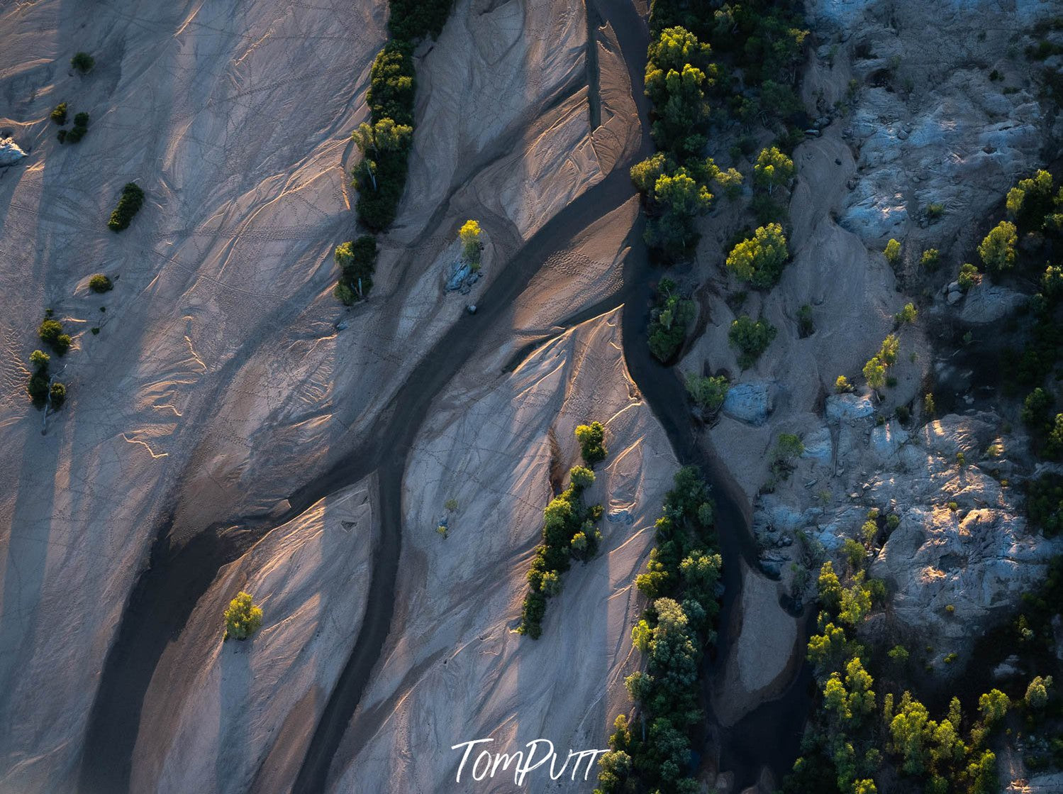 An aerial view of large stone-like land with a lot of small in-line trees on it, and some lines and curves as well, Dawn Light, Bow River, The Kimberley