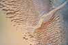 An aerial view of a desert-like land with a sequence of countless rounded zig-zag marks of brown color on it, and a thick pathway of sand color between the image connecting with the water, Derby #15 