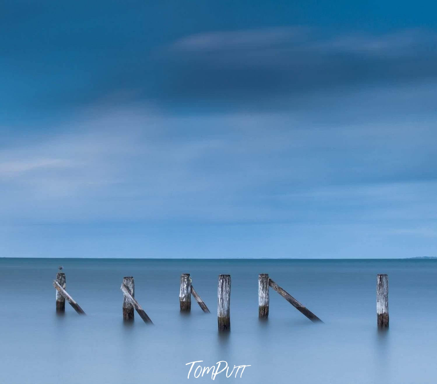 Long wood pillars having another one on 45 degrees with each inside the sea and half outside the water, Derelict Jetty, Hastings - Mornington Peninsula VIC