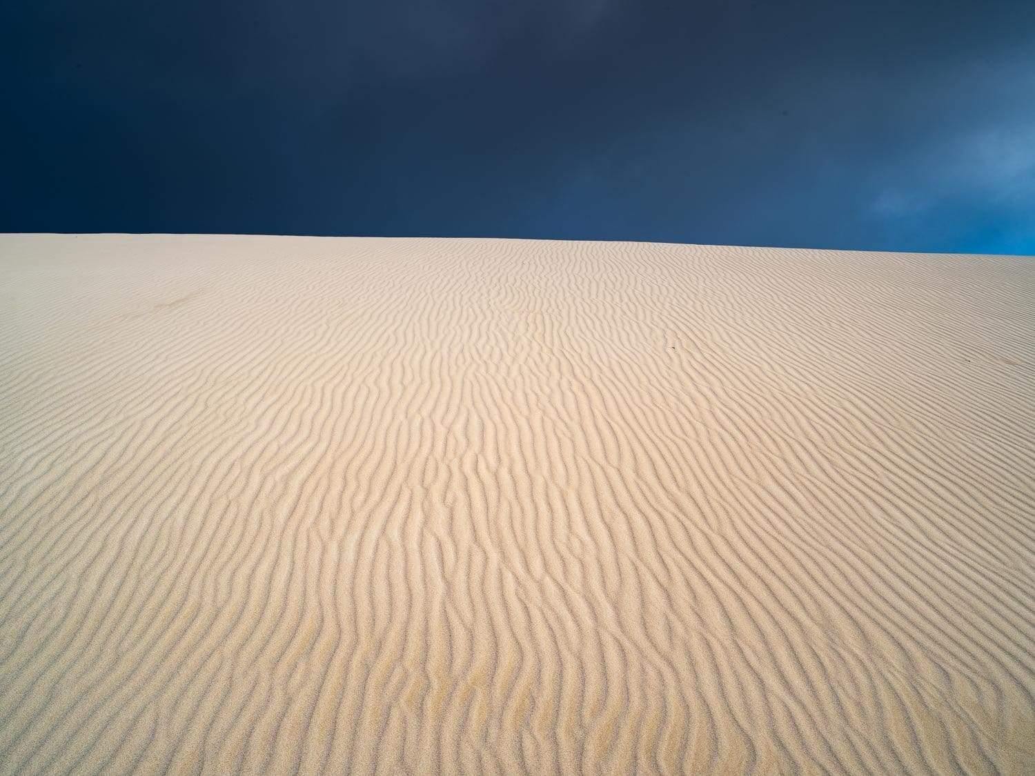 A large desert area with the natural line prints on it and a dark black sky in the far background, Desert Darkness - Kangaroo Island SA