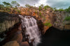 A beautiful mountain wall with some random steps following the below watercourse, and clear waterfall falling below with some greenery on the mountain walls, EAGLE FALLS - The Kimberley WA