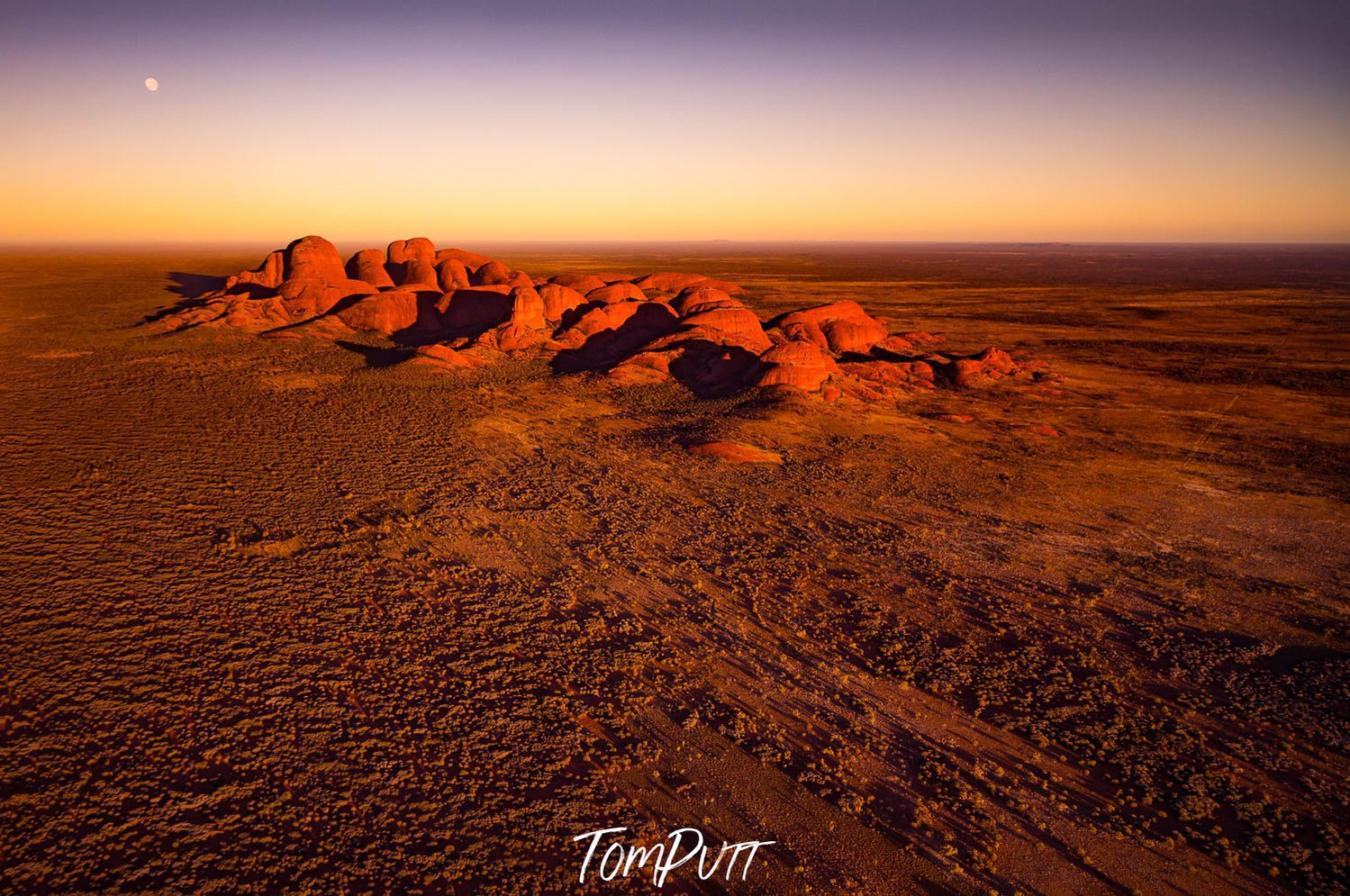 A shiny effect of sunlight on desert land with a group of small sand mounds and nothing else in the entire picture, Early Light, Kata Tjuta - Red Centre NT