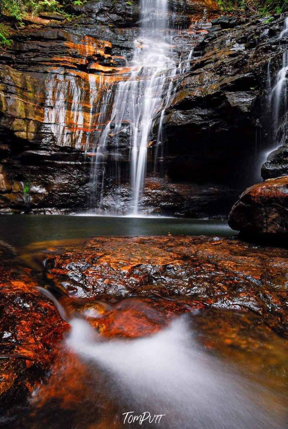 A beautiful waterfall from rock of orange and dark brown shade, some flat stones on the ground with the overflow of the water, Empress Falls #2 - Blue Mountains NSW