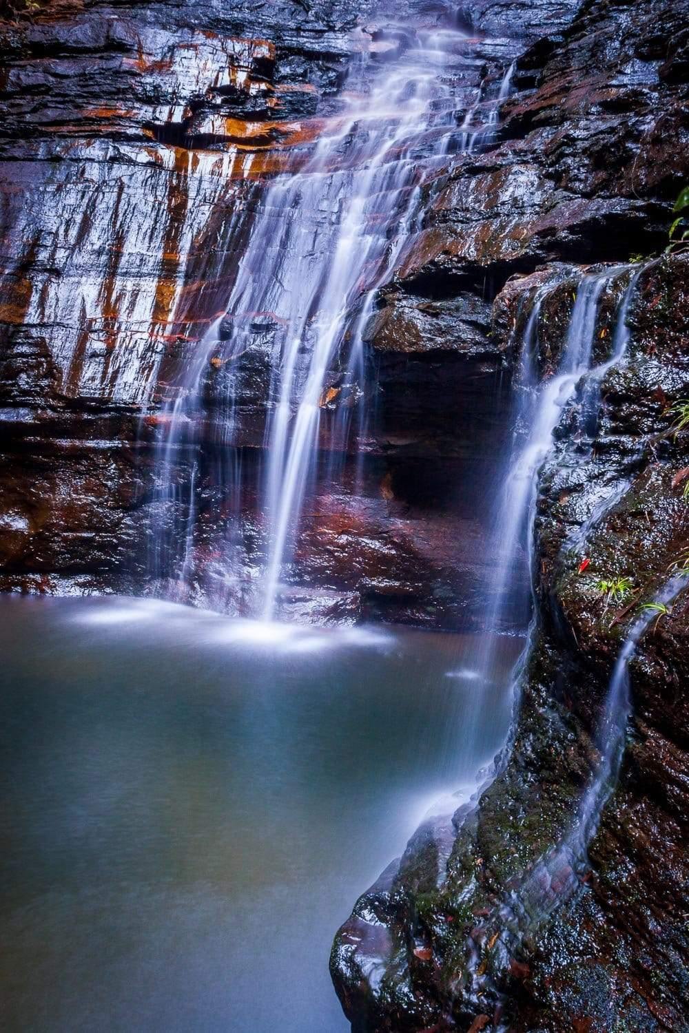 A dark view of the beautiful waterfall from rock of orange and dark brown shade, water, Empress Falls #3 - Blue Mountains NSW