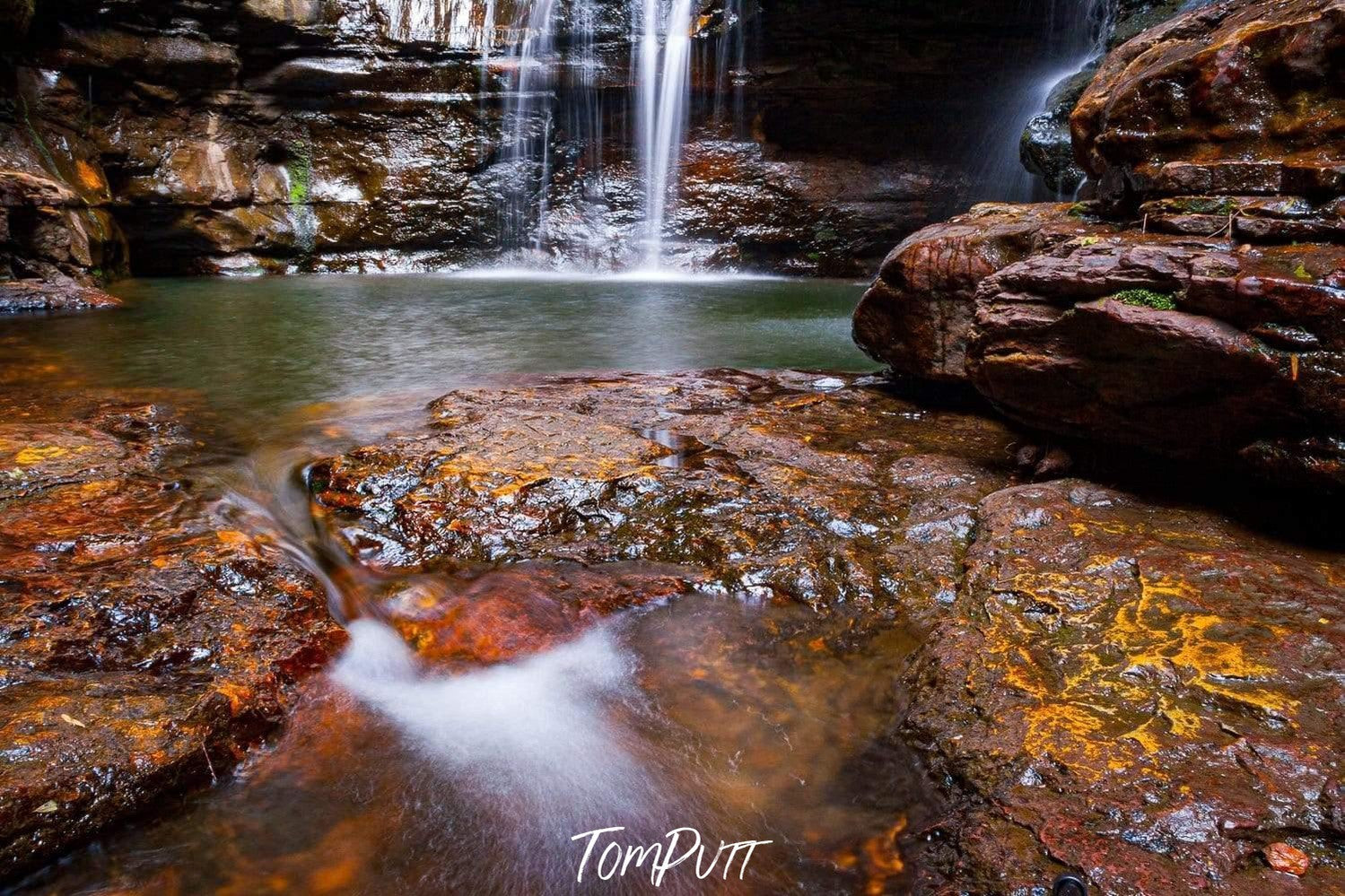 A beautiful waterfall from rock of orange and dark brown shade, some flat stones on the ground with the overflow of the water, Empress Falls - Blue Mountains NSW