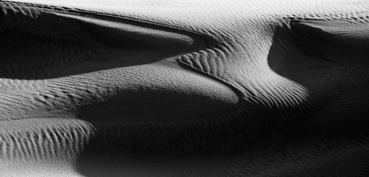 A black and white view of a desert with clean lines some big waves of sand, and a dark shadow hitting partially on the picture, Eyre Peninsula #7