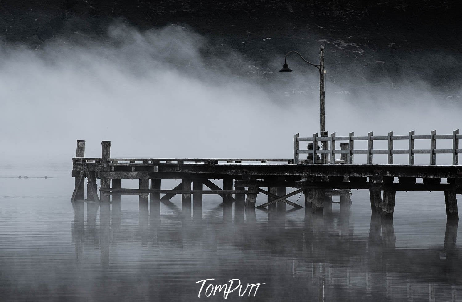 Dark view of a wooden bridge over a lake with clear reflection in the water, New Zealand #6