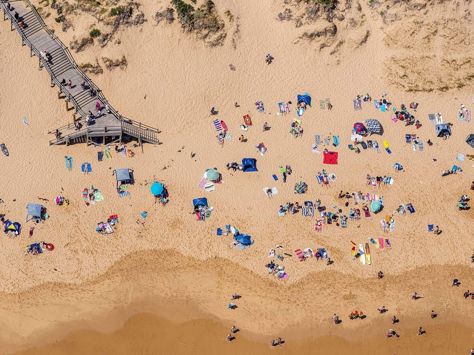 Aerial view of a seashore with many people enjoying, Gunnamatta Sunbaking - Mornington Peninsula VIC