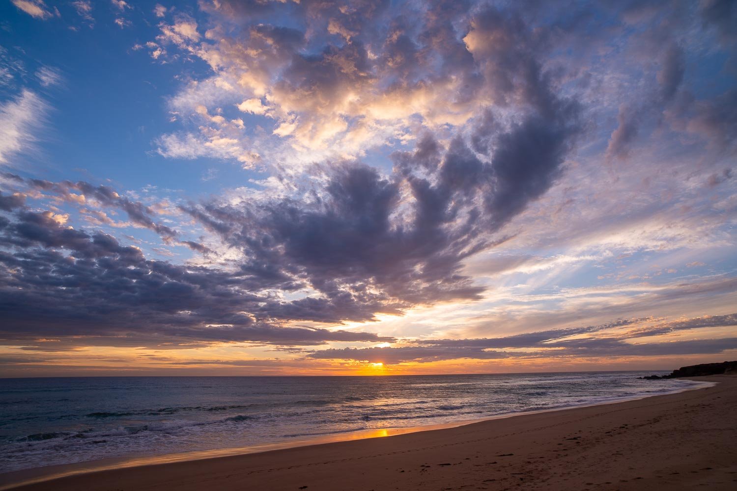 A beach with heavy giant black smoky clouds over it, Gunnamatta Sunset - Mornington Peninsula VIC 