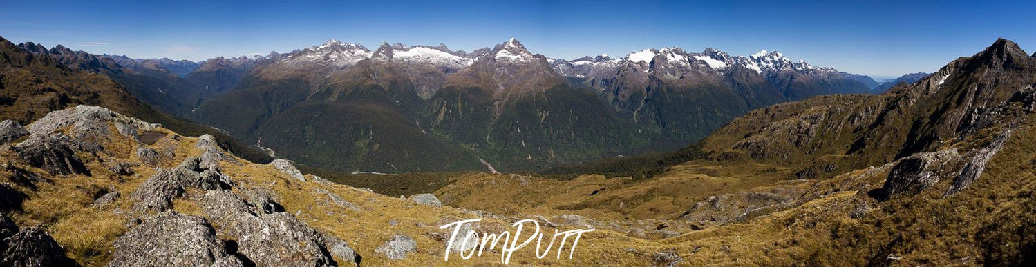 A green mountain area with a long mountain wall in the background, Harris Saddle panorama, Routeburn Track - New Zealand