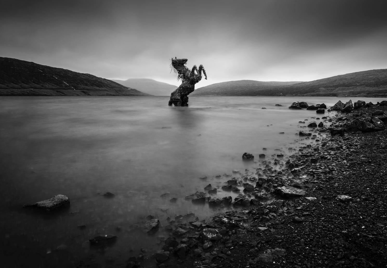 A dark horse sculpturein the water, Horse Sculpture, Faroe Islands