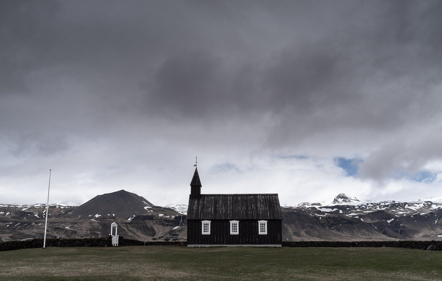 A long-shot view of a house in a park and some heavy rain clouds over it, Iceland #30