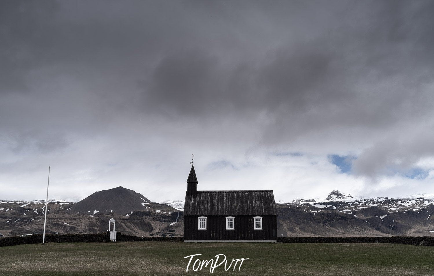 A long-shot view of a house in a park and some heavy rain clouds over it, Iceland #30