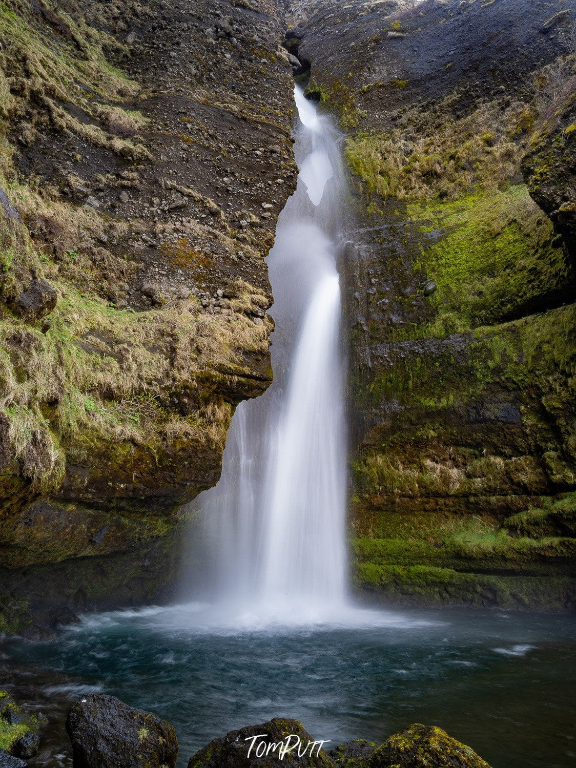 A beautiful waterfall coming from a hill area of a tall mountain wall, Iceland No.32