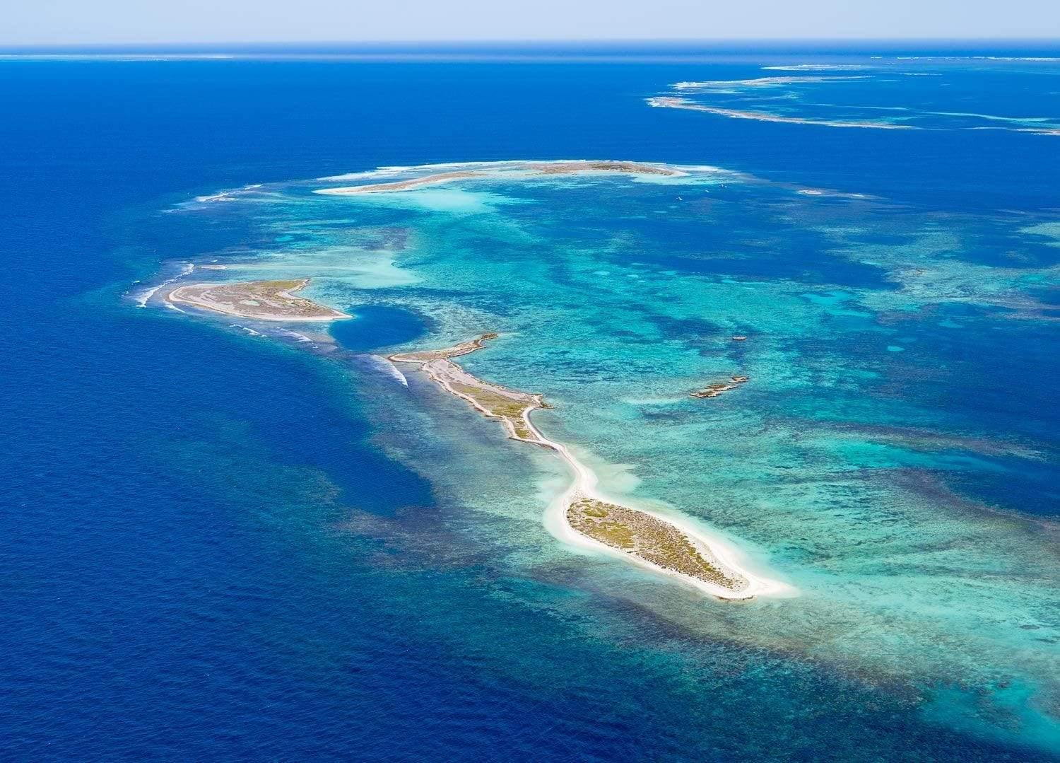 A large green area over a dark blue ocean, Island Paradise Houtman Abrolhos
