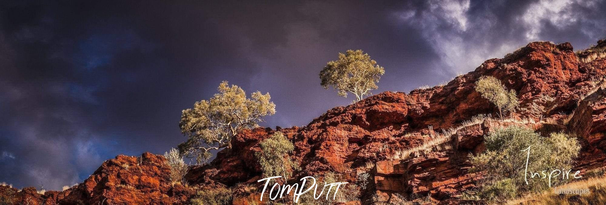 A long mountain wall with greenery, a giant group of black clouds over it, Karijini Light - Karijini, The Pilbara