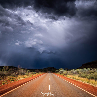 Empty road following a dark dense group of clouds, Karijini Road - Karijini, The Pilbara