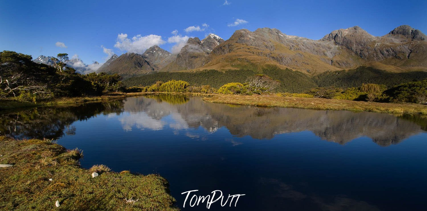 Beautiful series of mountains with a lake ahead of them, a reflection of mountains in the lake with a clear sky, Key Summit Reflection, Routeburn Track - New Zealand