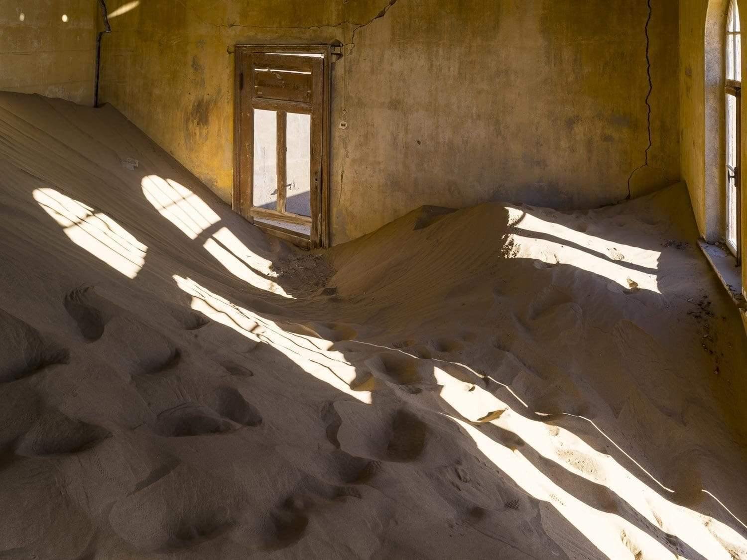 Empty room full of sand and a little sunlight coming, Kolmanskop #13 