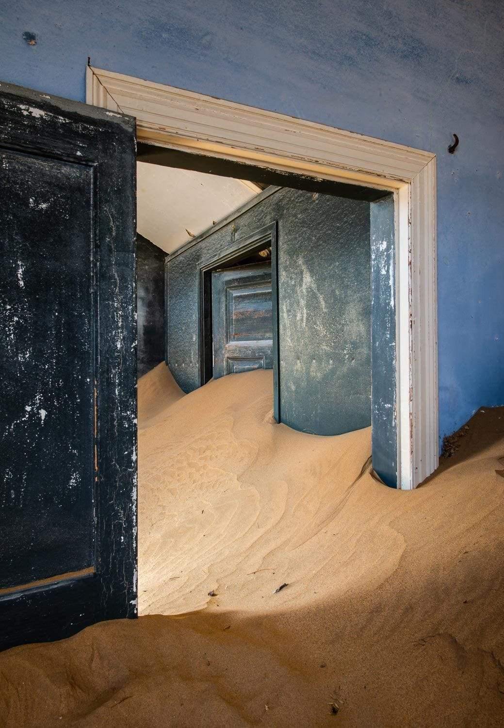 Making of a house room with open doors and a lot of construction sand inside, Kolmanskop #29