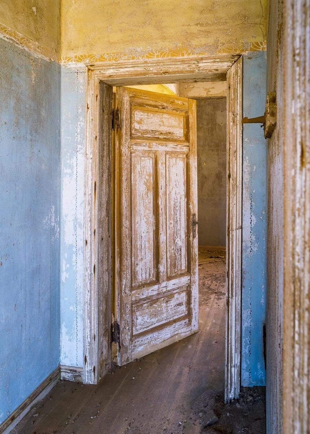 An old house's corridor with open room doors, Kolmanskop #31