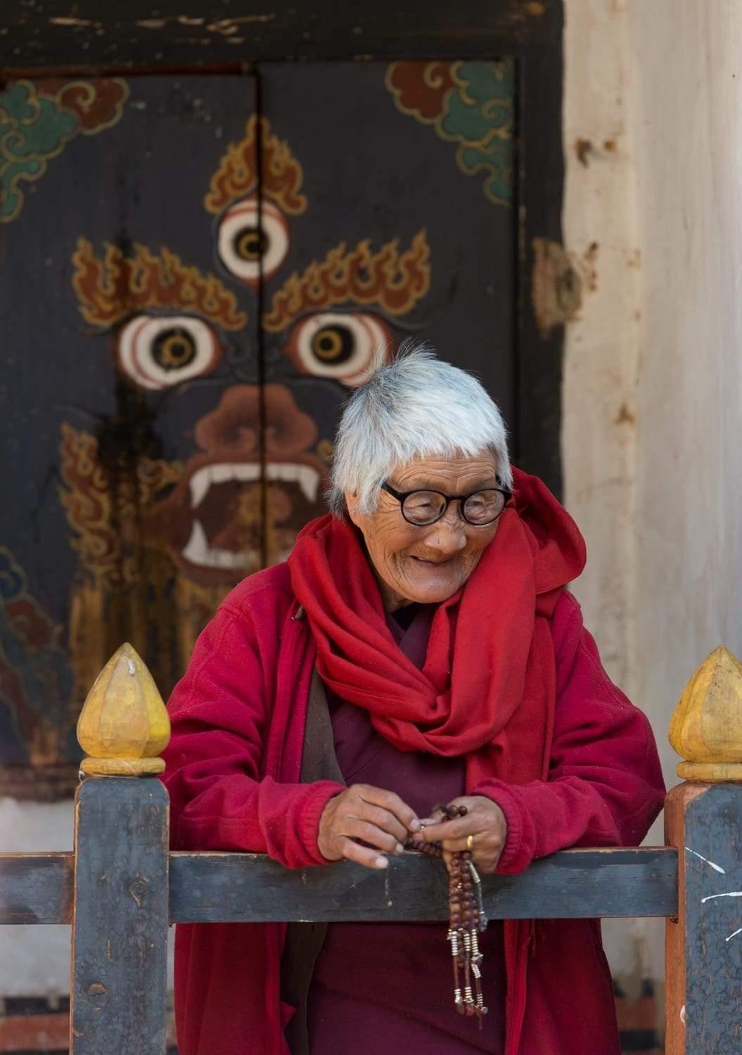 An old lady monk wearing a red gown, Lady Monk, Bhutan