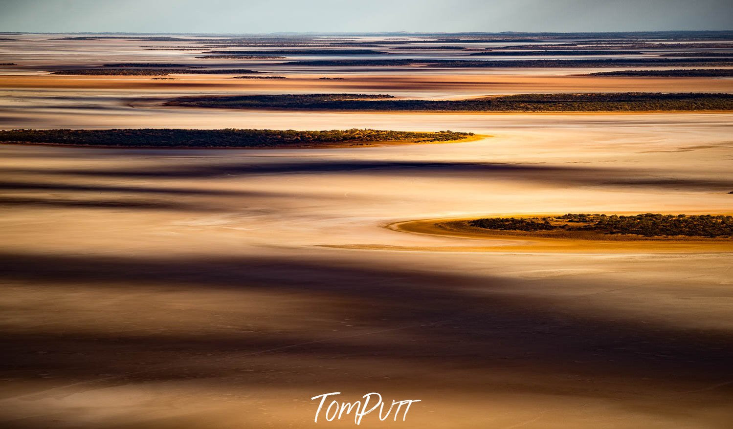 A desert-like view of a lake with golden and shiny effect, Lake Amadeus from the air - Northern Territory