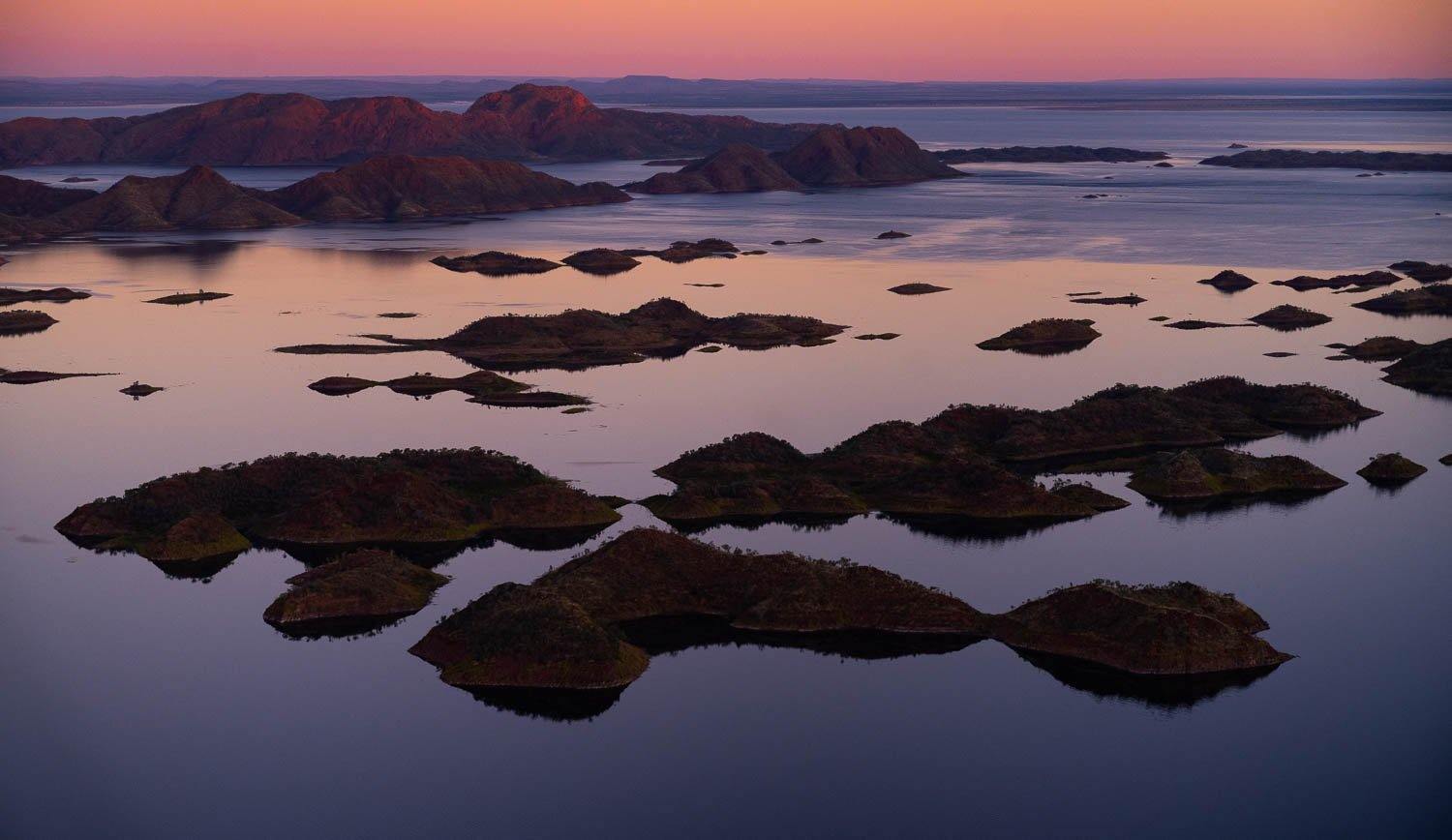 Many mounds of sand in the ocean, with a pinkish effect of sunset, Lake Argyle #14 - The Kimberley 