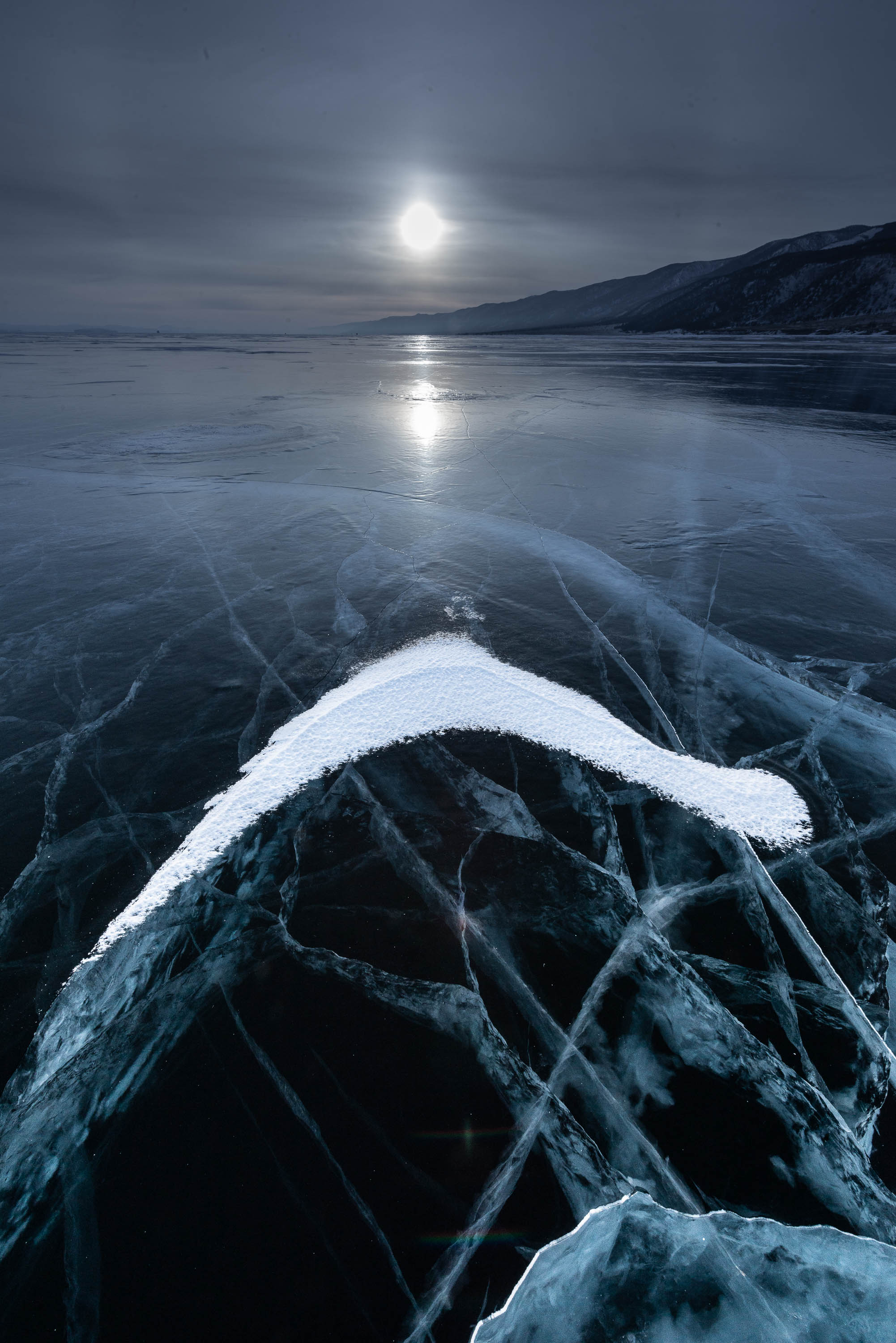 A frozen lake with some fresh snow, and a moonlight effect in the background, Lake Baikal #31, Siberia, Russia