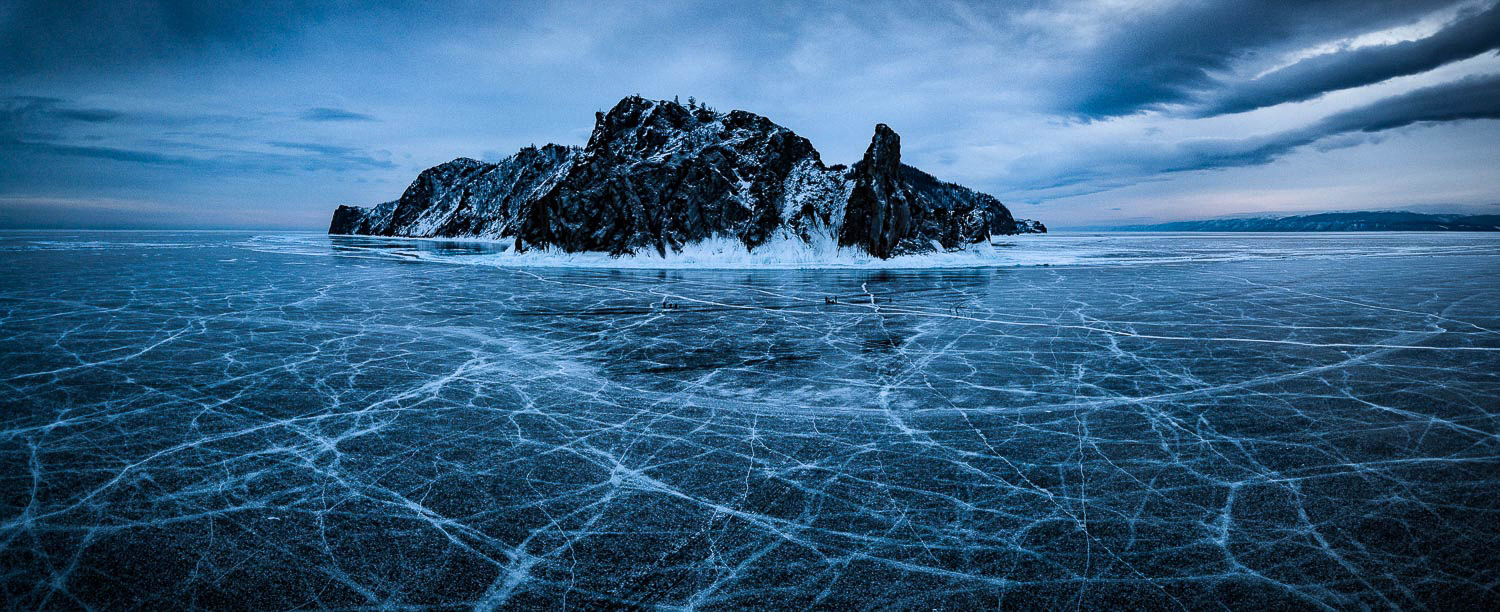 A frozen lake with a giant black mountain inside, Lake Baikal #48, Siberia, Russia