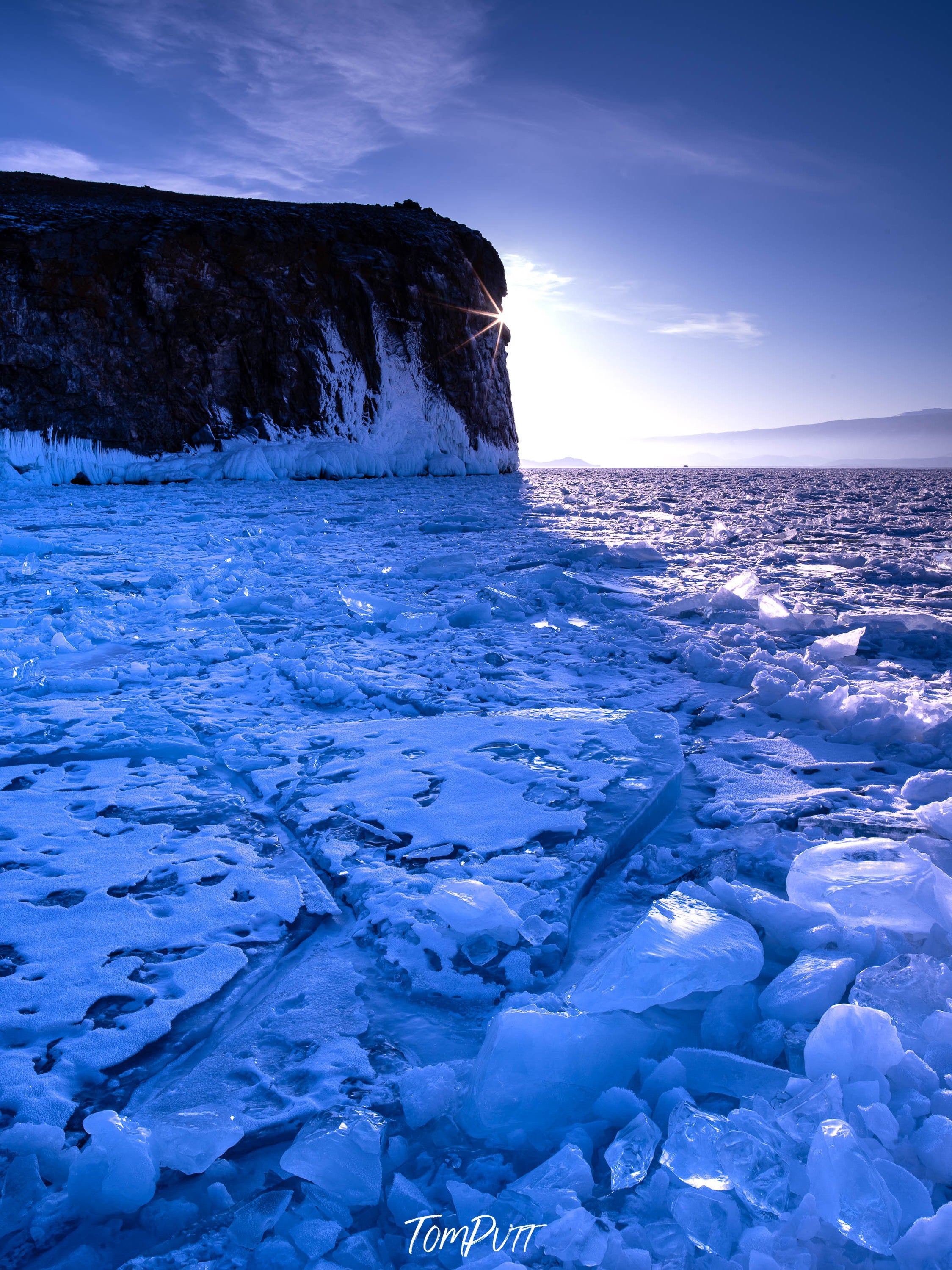 A large black mountain with a lot of ice-blue colored crystalline ice pieces in the foreground, Lake Baikal #6, Siberia, Russia