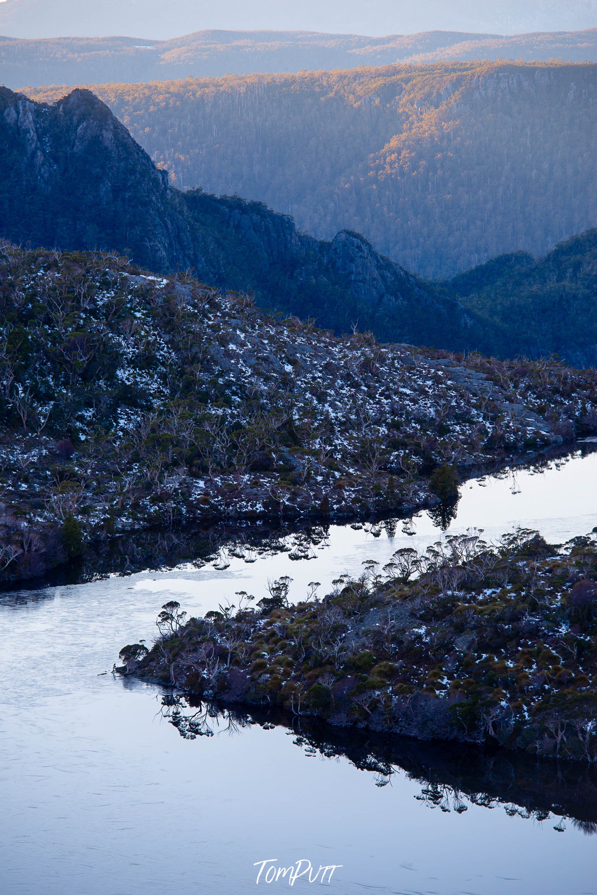 A large mountain wall with a snow-covered pathway on the land, Lake Hanson, Cradle Mountain, Tasmania