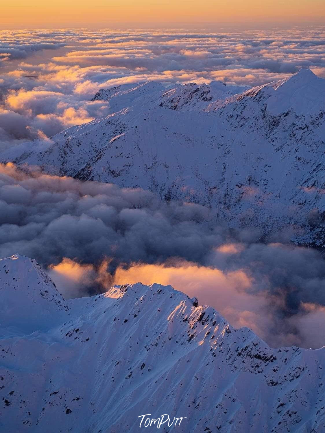 A drone shot of the walls of large mountains fully covered with snow, and a sunset view, Last Light Southern Alps Art