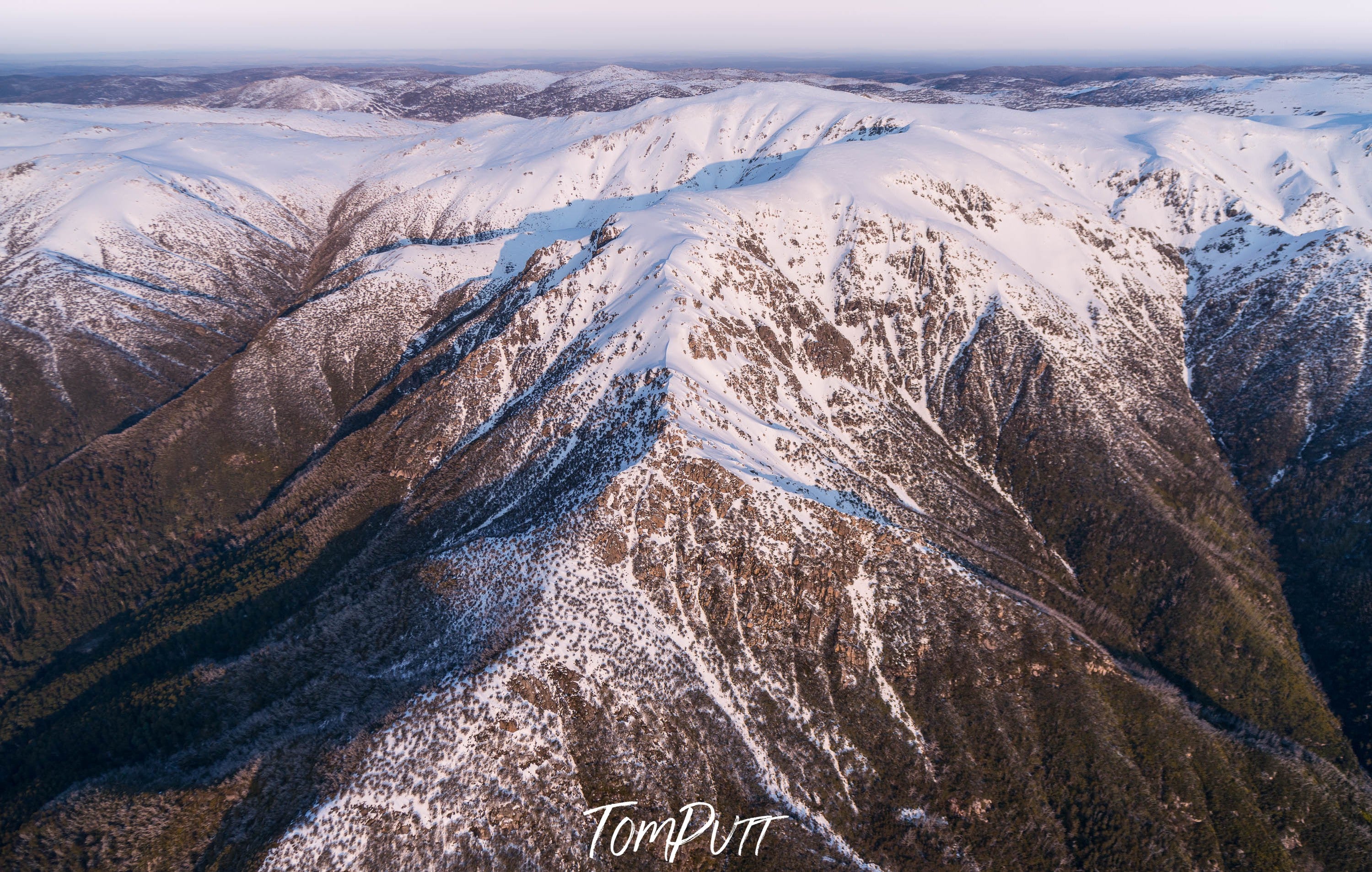 Large mountain walls with massive cracks and waves, Late Afternoon Light on the Western Face of the Snowy Mountains, New South Wales