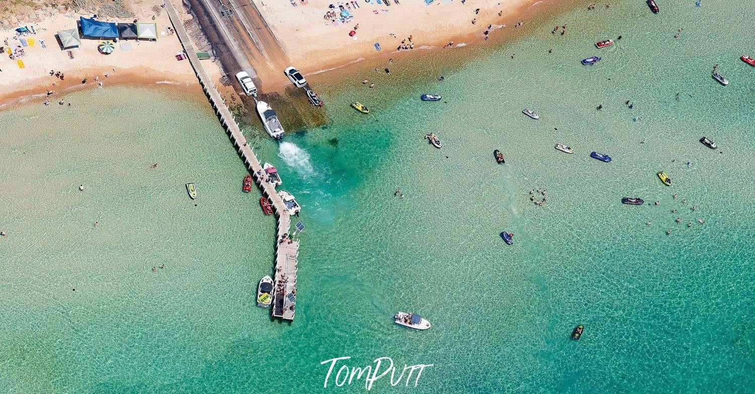 Aerial view of a sea-green beach with many people and boats, Launching Place, Safety Beach - Mornington Peninsula VIC