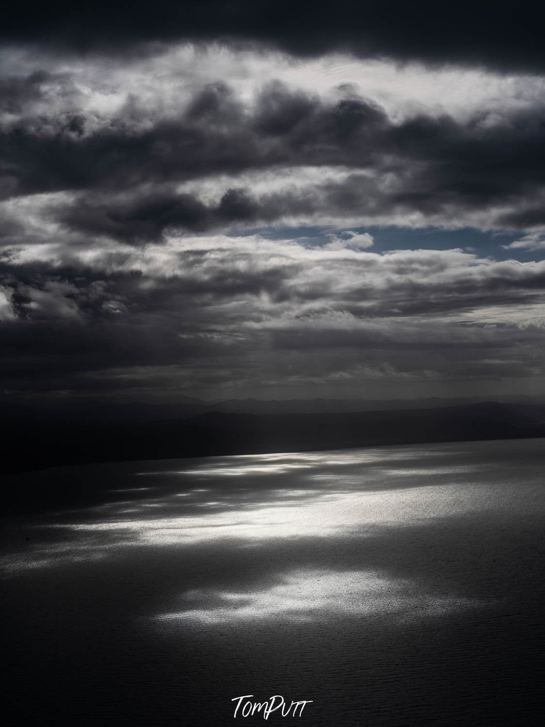 Dark view of a lake with stormy mountains over, Light on the water, Far North Queensland