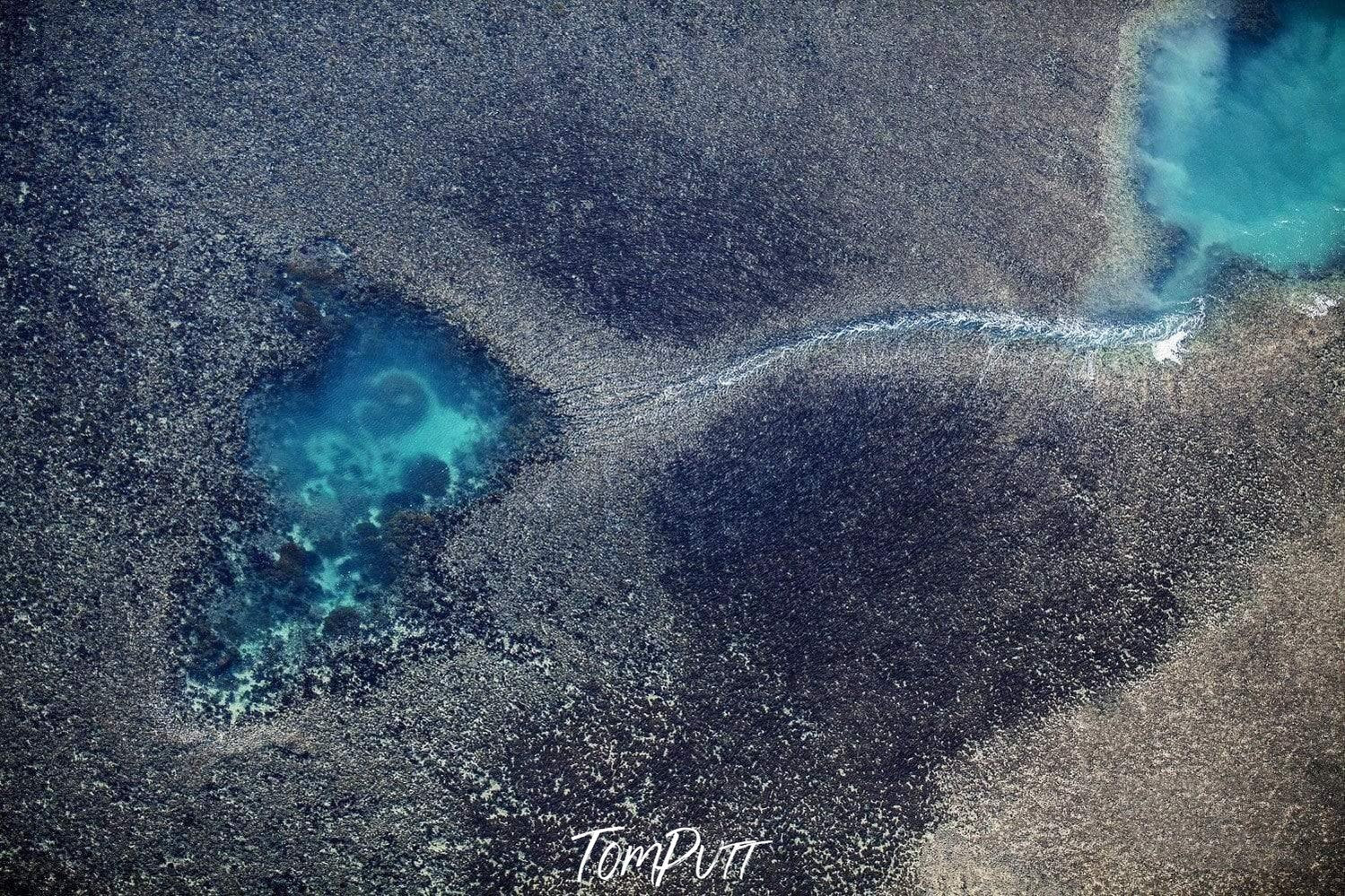 Aerial view of a rocky land with two unique small natural pools full of ice-blue water, Linked Pools