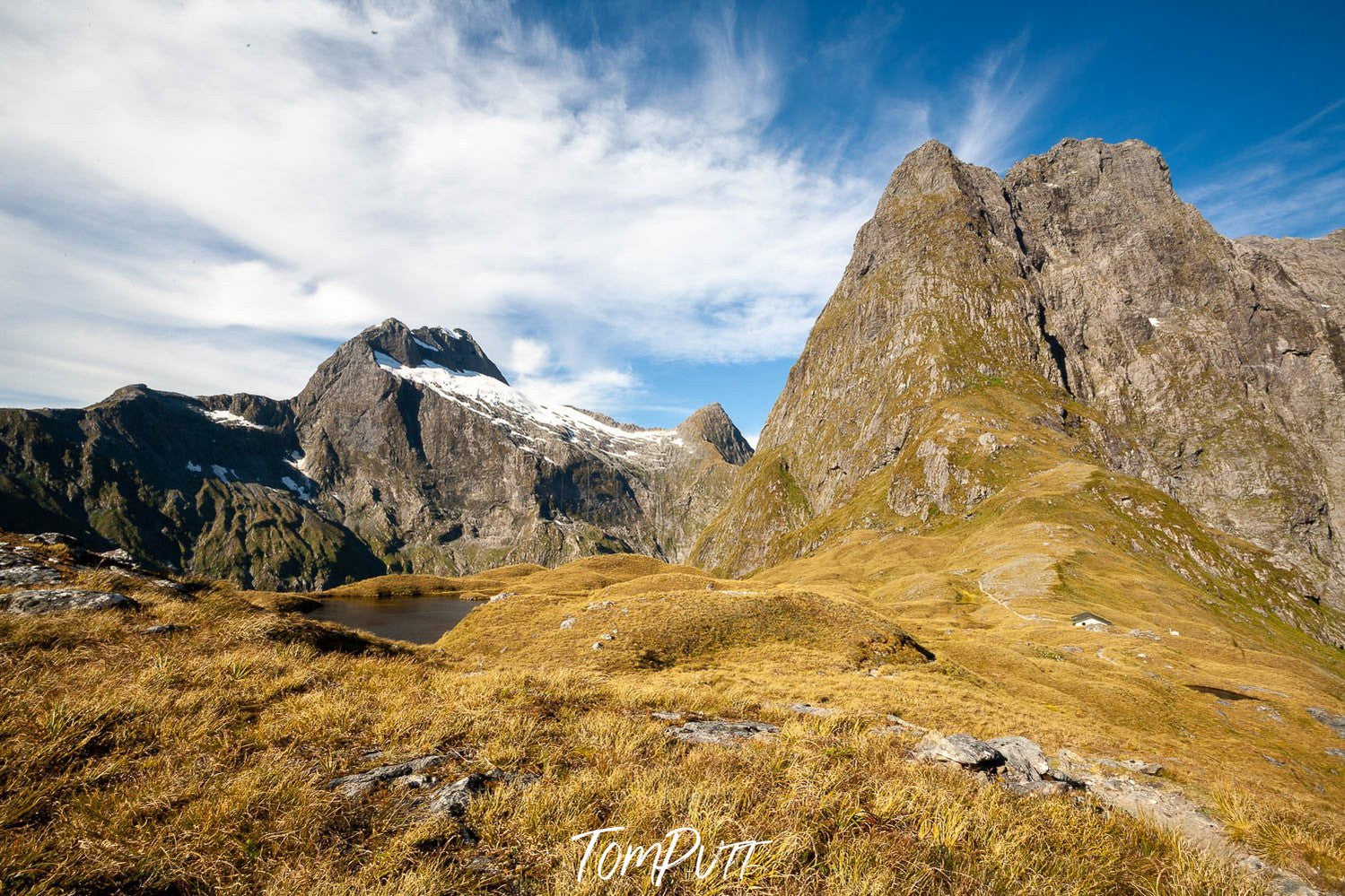 A long shot of a hill area with a lot of greenery, MacKinnon Pass, Milford Track - New Zealand 