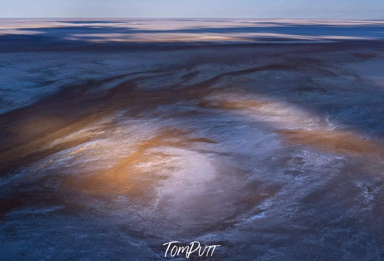 A large area of sand covered partially with powder-like sand and some sunlight coming and hitting on a specific middle area of the picture, Dancing Shadows