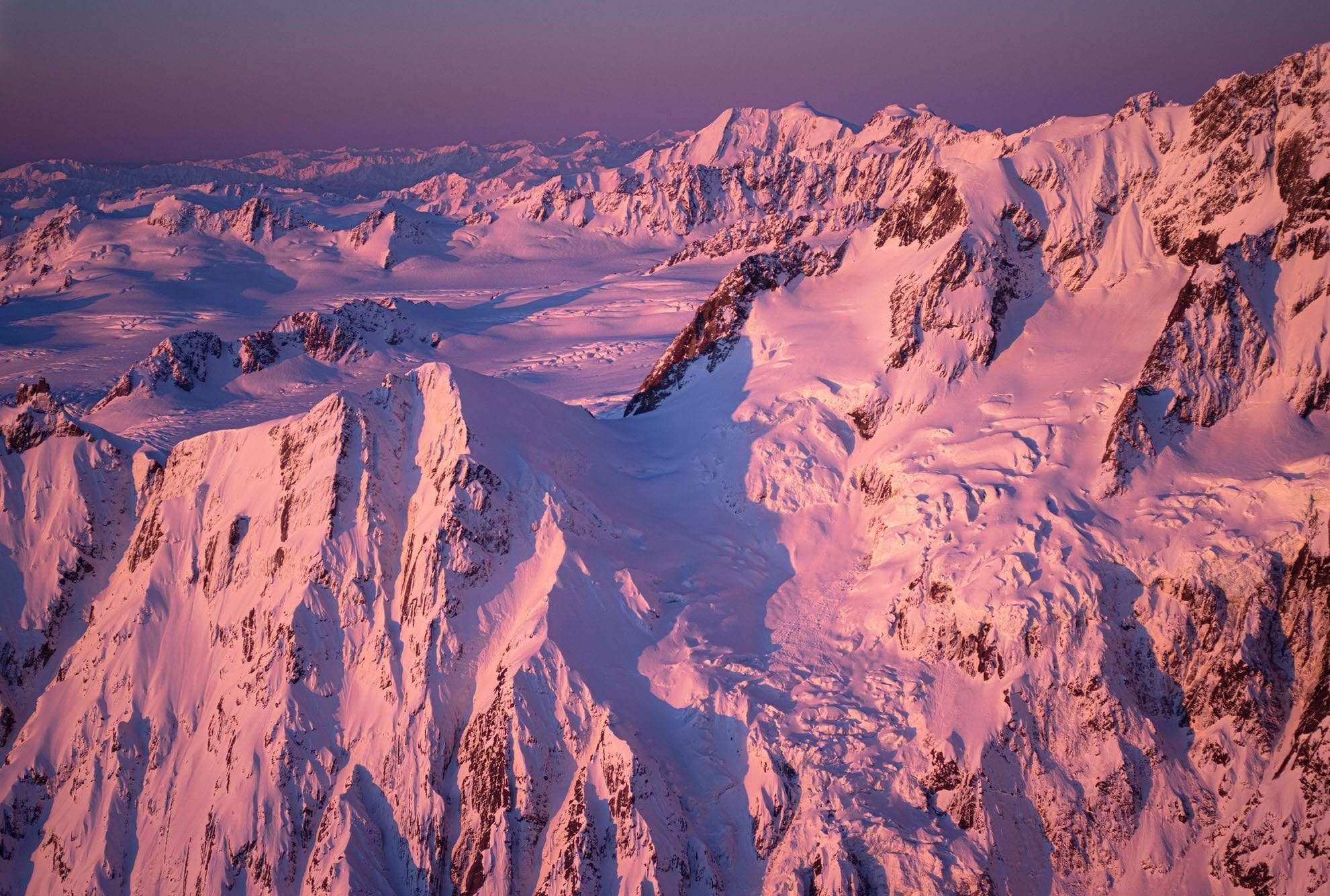 Aerial view of pinkish giant snow-covered mountain walls, Magenta Alps 