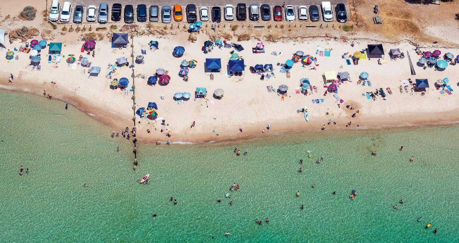 Aerial view of a green ocean with a lot of people on the beach, McCrae - Mornington Peninsula VIC