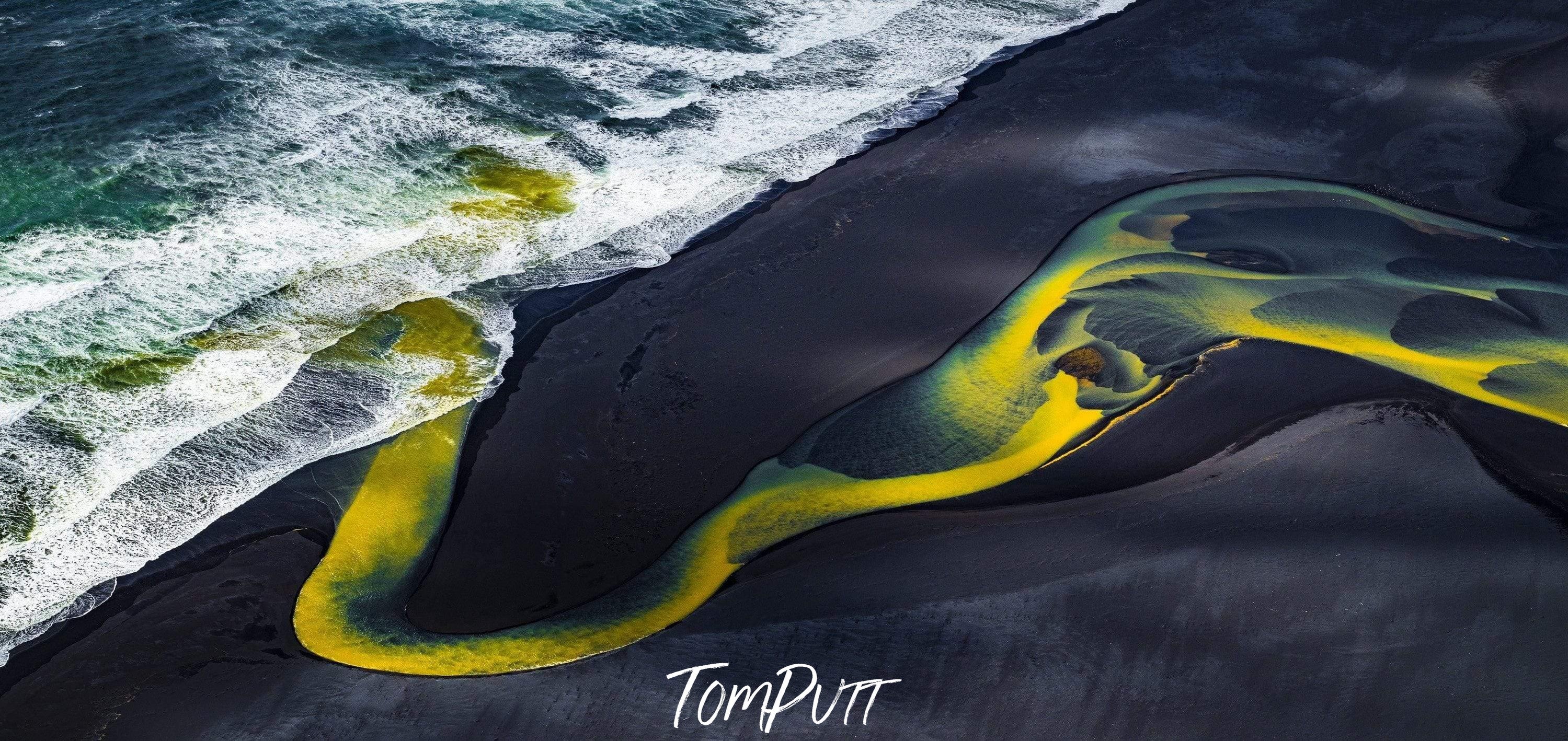 A large liquid wave of yellow and green color, entering in the sea, Meandering