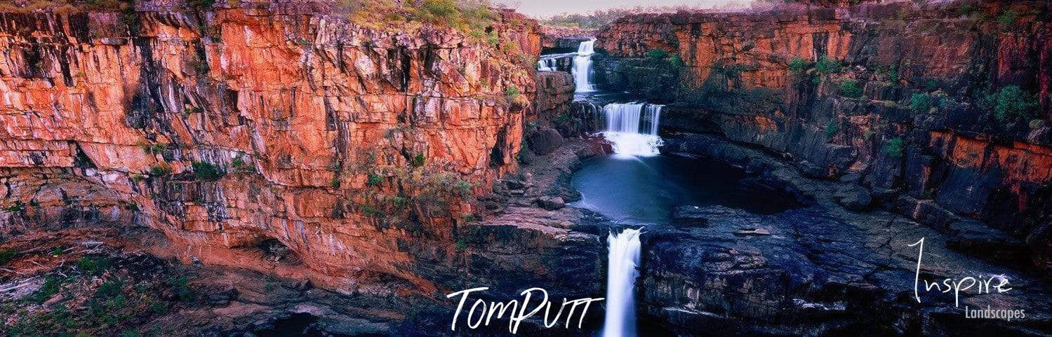 A long shot of nested waterfalls from a mountain wall and a lake, Mitchell Falls panorama, The Kimberley, Western Australia