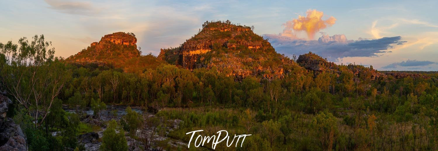 A couple of rocky mounds with a lot of small trees in surrounding and a clear sky over them, Arnhem Land 24 