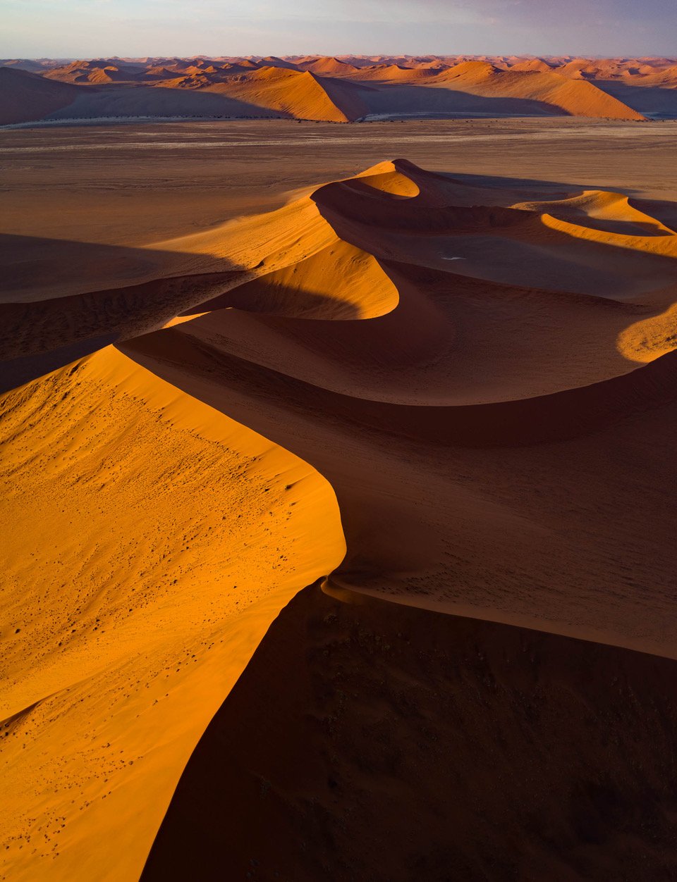 Aerial view of a wavy desert, with partially hitting sunlight, Namibia #5, Africa