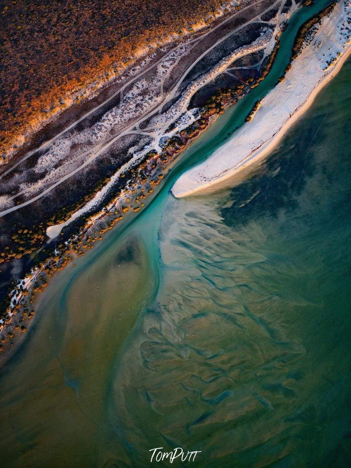 Aerial view of a beautiful lake corner with some weird white surface, and a greeny flat mountain wall beside, Outflow