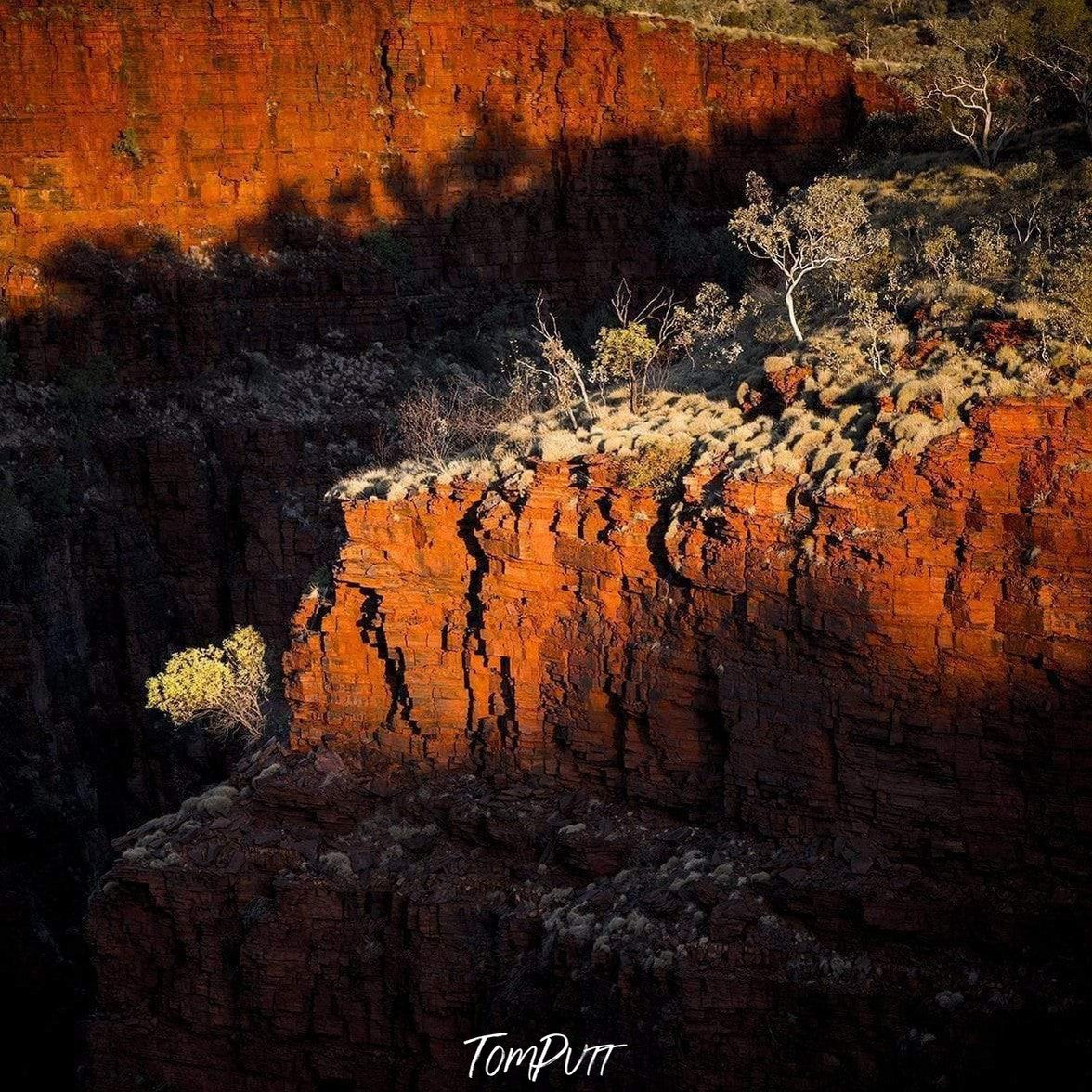 A drone view of an orangish-bricked mountain having some greenery over, with partially hitting sunlight, Oxers Sunset - Karijini, The Pilbara